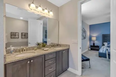 a bathroom with a sink and a large mirror at 7462 Themed Villa 6BD - Pool Spa-Game room in Orlando