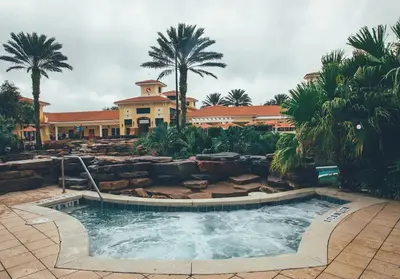 a pool in front of a building with palm trees at Amazing Private Villa @ Orang Lake Resort in Orlando