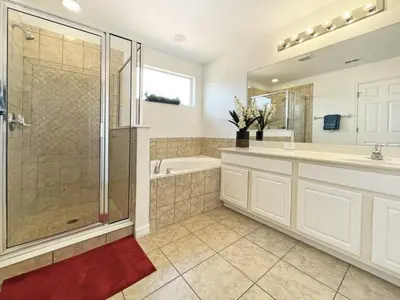 a bathroom with a shower and a tub and a sink at Mariel Oasis home in Kissimmee