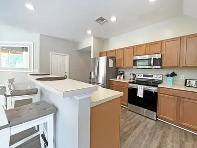 a kitchen with wooden cabinets and a counter top at Summer Sparkle home in Kissimmee