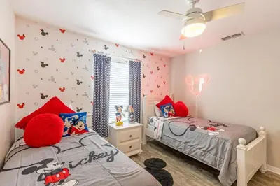 two twin beds in a bedroom with hello kitty wallpaper at Majestic Retreat townhouse in Kissimmee