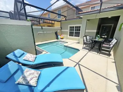 a small swimming pool with chairs and a table at Majestic Retreat townhouse in Kissimmee