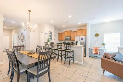 a kitchen and living room with a table and chairs at Majestic Retreat townhouse in Kissimmee