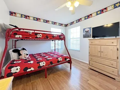 a childs bedroom with a red bunk bed and a dresser at Ainsdale Haven home in Kissimmee
