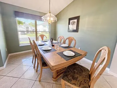 a dining room with a wooden table and chairs at Ainsdale Haven home in Kissimmee