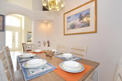 a dining room with a table with plates on it at Sweet Magnolia home in Orlando