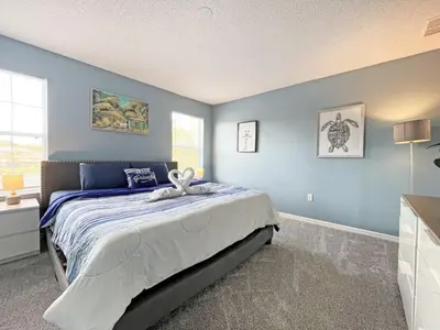 a bedroom with a large bed with blue walls at Villa Azul townhouse in Kissimmee