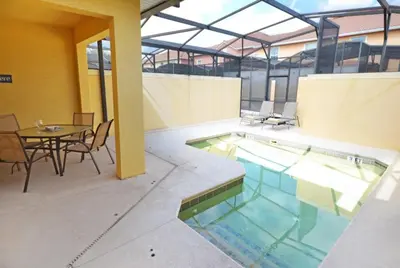 a swimming pool with a table and chairs and a table and a tablektop at California Palms condo in Kissimmee