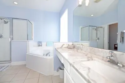 a bathroom with two sinks and a tub and a shower at Hideaway Dream home in Kissimmee