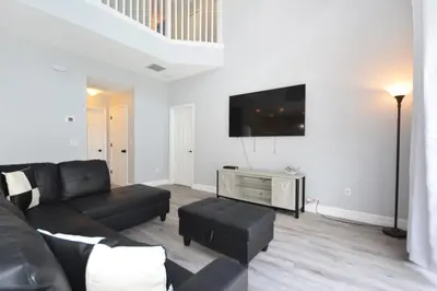 a living room with a couch and a flat screen tv at Hideaway Dream home in Kissimmee