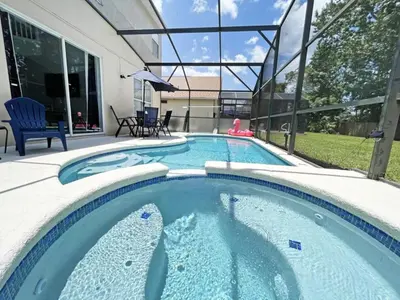 a swimming pool with blue water in a backyard at Hideaway Dream home in Kissimmee