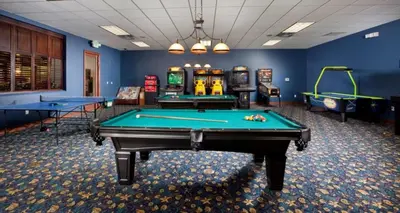 a billiard room with two pool tables and machines at Candy Palm townhouse in Kissimmee