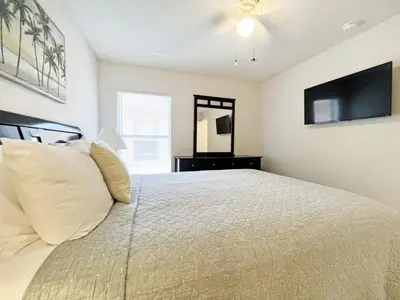 a bedroom with a bed with a television on the wall at Sunshine Villa villa in Kissimmee