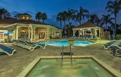 a pool at a resort with chairs and a building at Sunshine Villa villa in Kissimmee