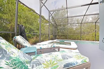 two beds in a glass house with a pool at Bamboo Palm home in Kissimmee
