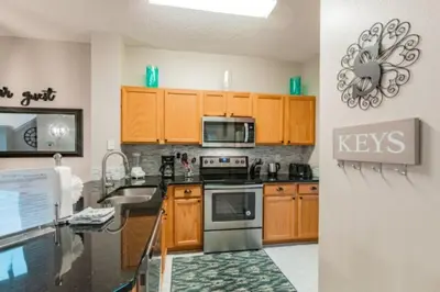 a kitchen with wooden cabinets and a stove top oven at Pompano Place townhouse in Kissimmee