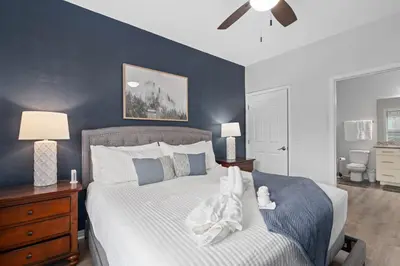 a bedroom with a bed with a blue accent wall at Beautiful & Cozy 4bd Home, Gated Community in Kissimmee