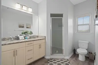 a bathroom with a toilet and a glass shower at Beautiful & Cozy 4bd Home, Gated Community in Kissimmee