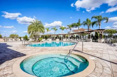 a pool at a resort with palm trees at Beautiful & Cozy 4bd Home, Gated Community in Kissimmee