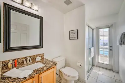 a bathroom with a toilet and a sink and a mirror at Clermont Vacation Rental with Pool 11 Mi to Disney in Orlando