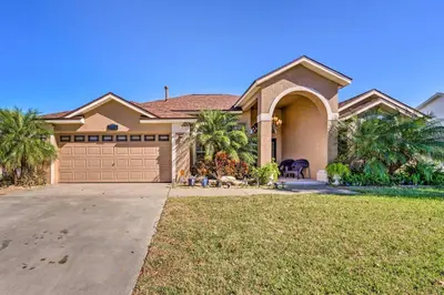a house with palm trees in front of a driveway at Clermont Vacation Rental with Pool 11 Mi to Disney in Orlando