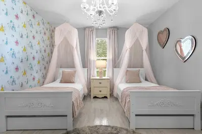a bedroom with two beds and a chandelier at Hidden gem! Gorgeous villa next to Disney in Kissimmee