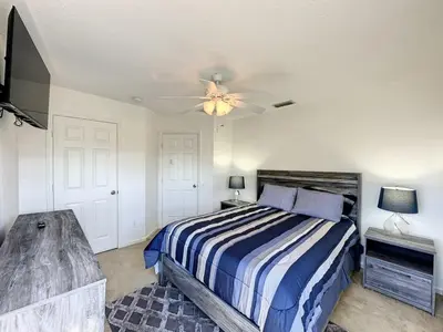 a bedroom with a bed and a ceiling fan at Luxury 6BD 3,5BA Pool Home in Windsor Palms Resort villa in Kissimmee
