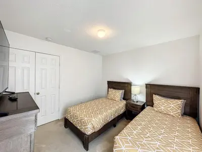 a bedroom with two beds and a desk and a tv at Luxury 6BD 3,5BA Pool Home in Windsor Palms Resort villa in Kissimmee