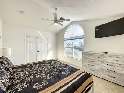 a bedroom with a bed and a ceiling fan at Luxury 6BD 3,5BA Pool Home in Windsor Palms Resort villa in Kissimmee