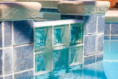 a pool with a water fountain with blue tiles at Large Home-Private Pool, Spa, and Pet Friendly Sleeps 12 in Orlando