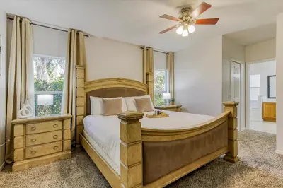 a bedroom with a large bed and a ceiling fan at Large Home-Private Pool, Spa, and Pet Friendly Sleeps 12 in Orlando