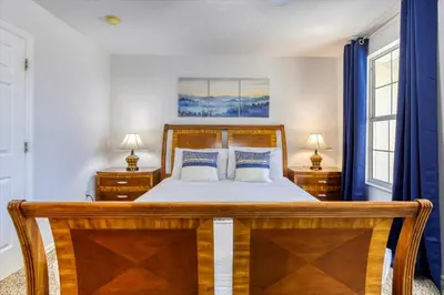 a bedroom with a wooden bed and two night stands at Large Home-Private Pool, Spa, and Pet Friendly Sleeps 12 in Orlando
