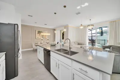 a kitchen with a sink and a refrigerator at Amazing Story Lake Town Home With Pool townhouse in Kissimmee