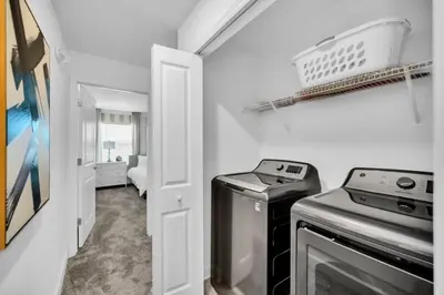 a small laundry room with a washer and dryer at Amazing Story Lake Town Home With Pool townhouse in Kissimmee