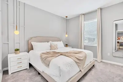 a white bedroom with a bed and a mirror at The Ultimate New 15 Bedroom 16 Bathroom Vernada villa in Kissimmee