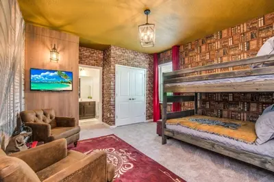 a bedroom with a bunk bed and a couch at The Ultimate New 15 Bedroom 16 Bathroom Vernada villa in Kissimmee
