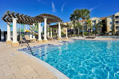 a pool at a resort with chairs and umbrellas at Windsor Hills Resort Poolside Ground Floor 3 Bed Condo in Orlando