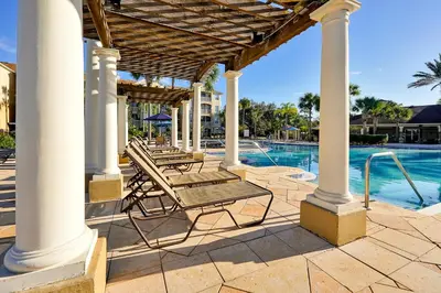 a patio with chairs and a swimming pool at Windsor Hills Resort Poolside Ground Floor 3 Bed Condo in Orlando