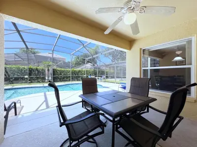 a dining room with a table and chairs and a pool at Lovely 3-Bedroom Pool Villa-1445SCD villa in Orlando