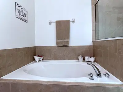 a large bath tub in a bathroom with a sink at Cozy 4 Bed 3 Bath Pool Hm with Game Room-4450NP home in Kissimmee