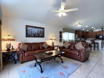 a living room with brown leather couches and a table at Cozy 4 Bed 3 Bath Pool Hm with Game Room-4450NP home in Kissimmee