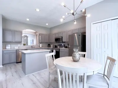 a kitchen with a table and chairs and a refrigerator at Spacious 7Bd Pool Gm Hm Terra Verde Resort-211HBL home in Kissimmee