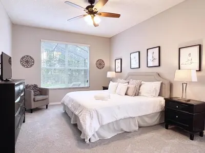 a bedroom with a white bed and a ceiling fan at Spacious 7Bd Pool Gm Hm Terra Verde Resort-211HBL home in Kissimmee
