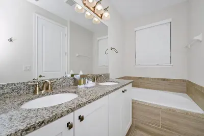a white bathroom with two sinks and a tub at Inviting Home Near Disney With Private Pool And Waterpark & Resort Access At Encore Resorts Reunion - 7578Mr in Kissimmee