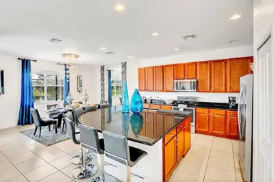 a kitchen with a large island with a counter top at 6BR Luxury Home w Pool Hot Tub and Games room in Kissimmee