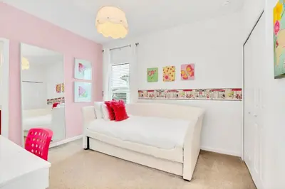 a living room with a white couch and a red chair at 6BR Luxury Home w Pool Hot Tub and Games room in Kissimmee