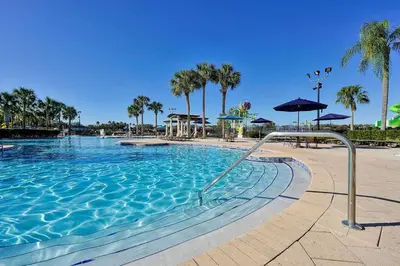 a large swimming pool with palm trees in a resort at Mickey's Welcome Inn - Closest Resort to Disney in Orlando