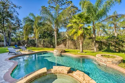 a swimming pool in a yard with a bench and trees at Walk to Lake Stunning Central Florida Home! in Lake Mary