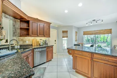 a large kitchen with wooden cabinets and a large island at Walk to Lake Stunning Central Florida Home! in Lake Mary