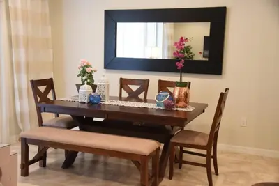 a dining room table with chairs and a mirror at Gorgeous 4Bd TH Pool Windsor at Westside-2018WW home in Orlando